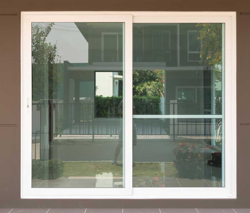 Exterior view of modern white-framed Sliding Windows Atlanta with large glass panels, offering smooth operation, clear visibility, and a sleek contemporary residential design.