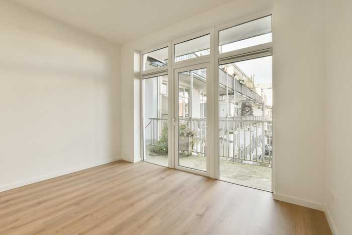 Spacious empty living room with large sliding glass doors and balcony view, highlighting expert Window Replacement Montgomery for modern residential window upgrades