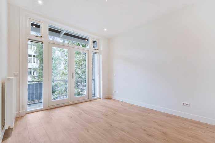 Bright modern living room with large French-style glass doors and balcony, showcasing professional Window Replacement Montgomery for residential window renovation