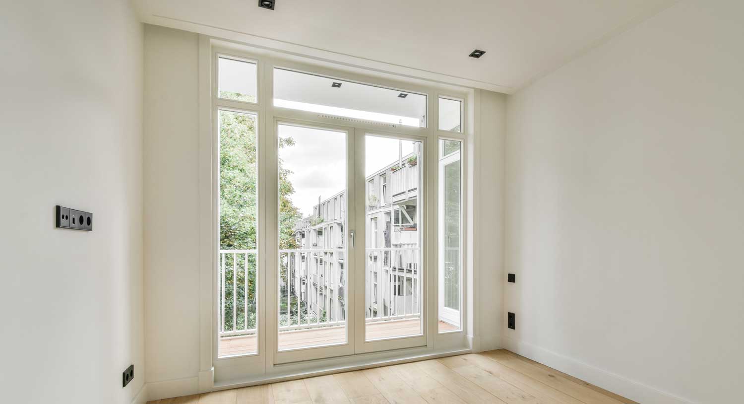 Modern bright room with large glass balcony doors and tall windows, showcasing professional Window Replacement Montgomery for residential home upgrades