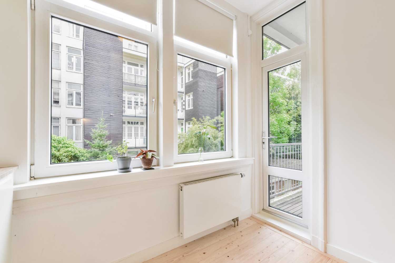 Bright apartment interior with modern white-framed windows and glass door leading to balcony, highlighting professional Window Replacement Sylacauga, AL for energy-efficient residential upgrades