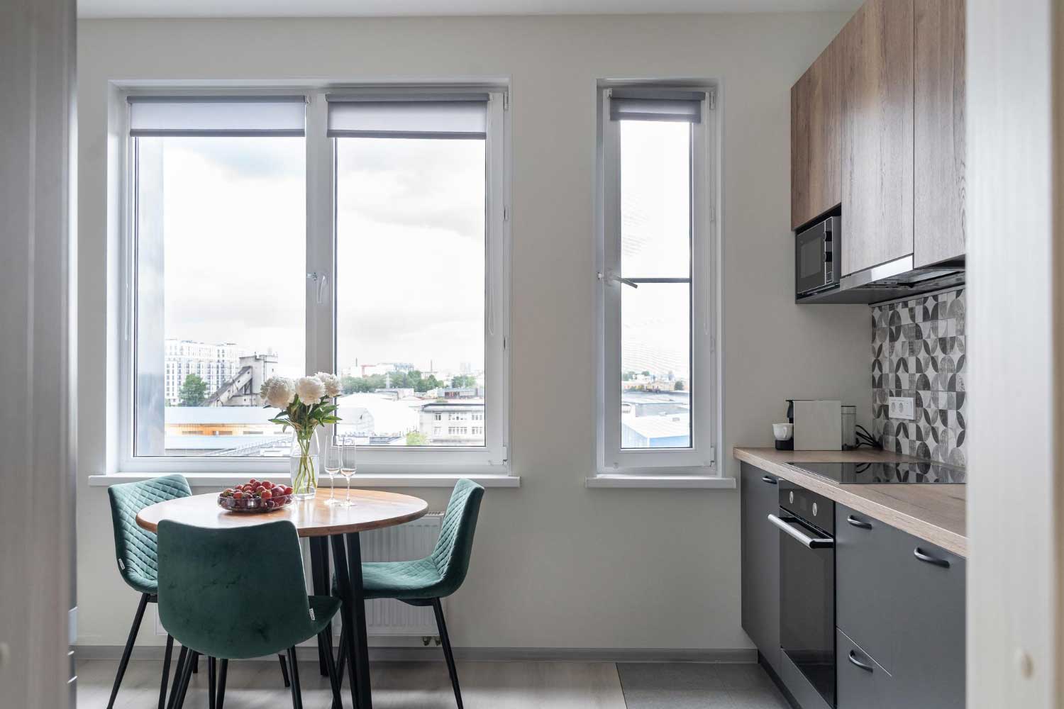 Modern kitchen and dining area with large white-framed windows providing city views and natural light, highlighting professional Window Replacement Tuscaloosa for residential window upgrades