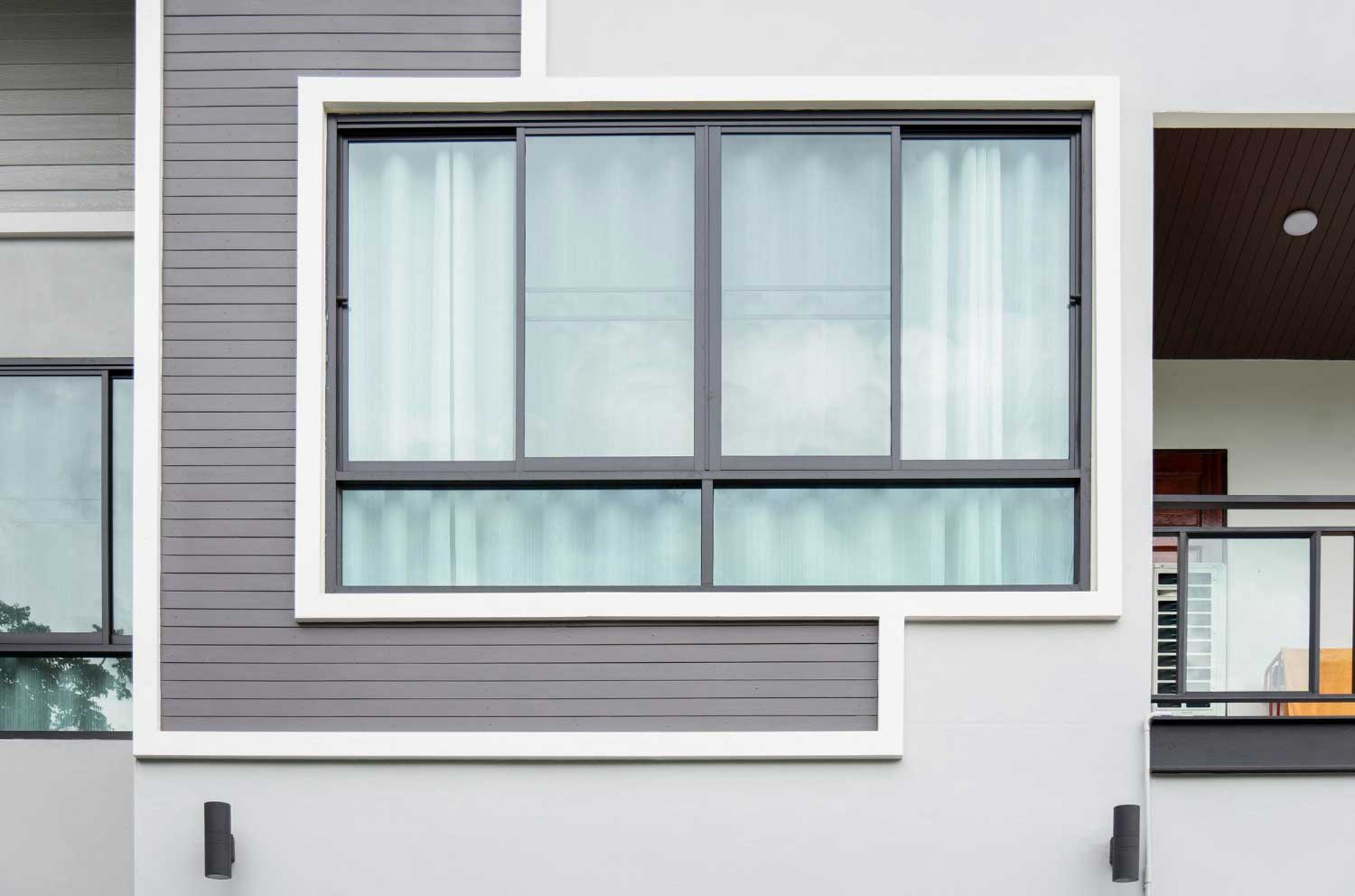 Exterior view of modern building with large sliding glass window and contemporary facade, showcasing professional Window Replacement Wedowee, AL for residential and commercial properties